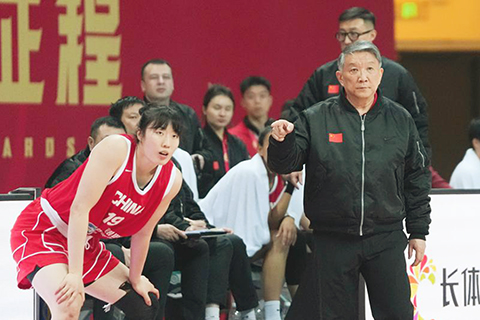 ◎ 三月四日,中國隊主教練宮魯鳴(右前)在場邊指揮。在湖南長沙舉行的中國女籃熱身賽中,中國隊通過加時賽七十四比六十九戰勝巴西隊。(新華社記者陳振海攝)