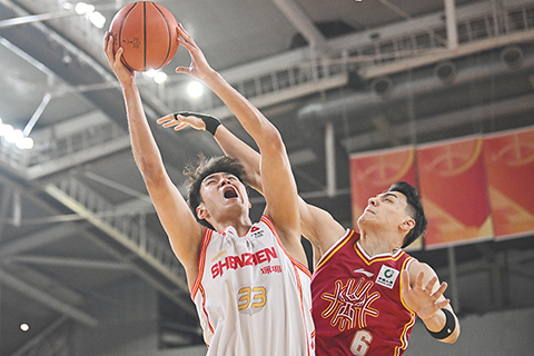 ◎ 4月9日,深圳馬可波羅隊球員王浩然(白衣)上籃。CBA常規賽第36輪比賽中,山西汾酒隊主場以98比103不敵深圳馬可波羅隊。(中新社記者 韋亮 攝)