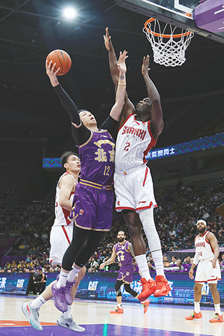◎ 4月13日,在北京國家體育館舉行CBA常規賽比賽中,北京控股隊主場102比89戰勝山西汾酒隊。圖為北京控股隊沈梓捷(紫衣)在比賽中上籃。(中新社記者 韓海丹 攝)